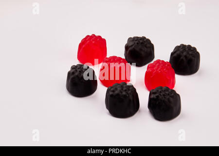 Nero e rosso jelly caramelle su sfondo bianco. Foto Stock