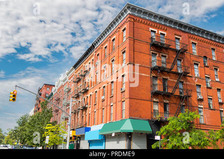 Edificio di mattoni rossi con scale antincendio su edificio classico parete nella città di New York Foto Stock