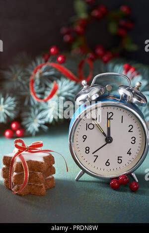 Saluto Anno Nuovo design della scheda. Natale Abete rami, bacche rosse, star cookies e blue vintage sveglia impostata da cinque a dodici. Foto Stock