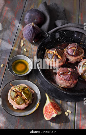 Fichi alla griglia ripiene di ricotta, pinoli e miele sul legno scuro tavolo rustico Foto Stock