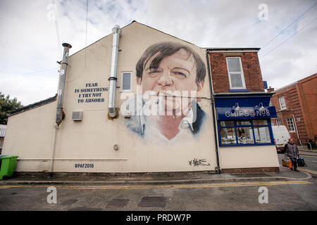 Prestwich, Regno Unito. 1 ottobre 2018. Akse p19, artista di graffiti, completa il suo ritratto del frontman "The Fall" Mark E.Smith, sul lato di un negozio di chip a Manchester. Il cantante 'The Fall', morto nel gennaio 2018, viene commemorato nella sua città natale di Prestwich, Greater Manchester per un Arts Festival. Credit: Howard Harrison/Alamy Live News Foto Stock