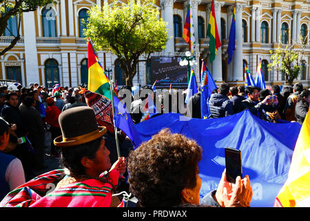 La Paz, Bolivia, 1 ottobre 2018. La gente guarda la lettura della sentenza per il caso "obbligo di negoziare l'accesso all'Oceano Pacifico (Bolivia contro Cile)" presso la Corte internazionale di giustizia dell'Aia su uno schermo gigante in Plaza Murillo. La Bolivia ha presentato il caso alla CICJ nel 2013; la Bolivia ha perso la sua provincia litoranea verso il Cile durante la guerra del Pacifico (1879-1884) e i negoziati precedenti non hanno compiuto alcun progresso dal punto di vista della Bolivia. Credit: James Brunker/Alamy Live News Foto Stock