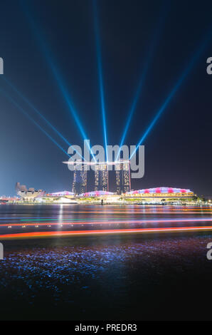 Faretti da Marina Bay Sands Hotel e sentieri di luce da una sulla bumboat. Foto Stock