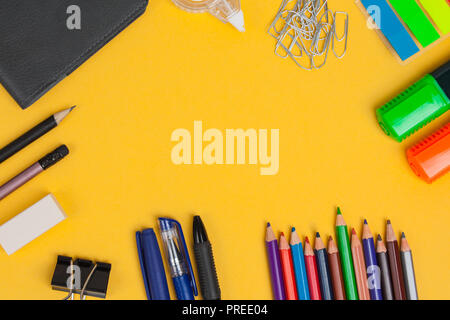 Scuola e forniture per ufficio giacciono su sfondo giallo. Lay piatto. Foto Stock