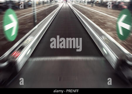 Prospettiva un ampio angolo di visione del moderno azzurro illuminato e spaziose ad alta velocità commerciale mobile escalator con rapido sentiero sfocata del corrimano ho Foto Stock