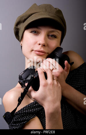 Bruna ragazza in studio, nelle mani della sua macchina fotografica Foto Stock