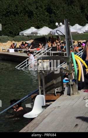 Vouliagmeni Atene Grecia turisti sul Lago Vouliagmeni una Spa naturale - una volta era una caverna ma il tetto della grotta cadde in causa dell'erosione del Foto Stock