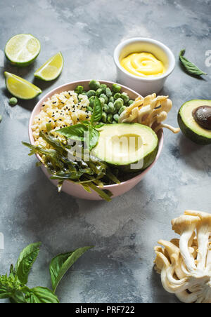 Ciotola di Buddha ricetta con la quinoa, avocado, lenticchie, funghi, cavolo riccio di mare su sfondo di calcestruzzo. Foto Stock