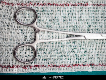 Forbici chirurgiche su un bendaggio, immagine concettuale Foto Stock