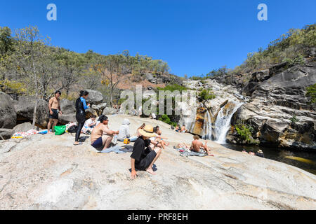 I turisti in un momento di relax a Emerald Creek Falls in una giornata di sole, vicino Mareeba Aeroporto, altopiano di Atherton, estremo Nord Queensland, FNQ, QLD, Australia Foto Stock