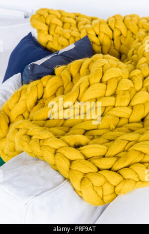 Di colore giallo brillante spessa coltre di tessuto sul divano Foto Stock