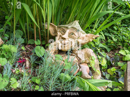 Gnomo da giardino con impish sorridere pensando - argilla nana in giardino Foto Stock