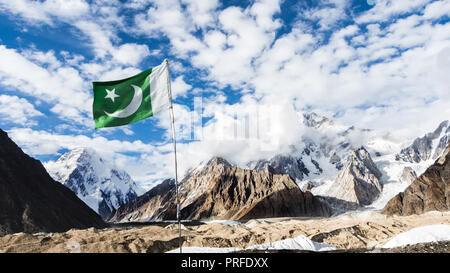 Il Pakistan bandiera in concordia sul ghiacciaio del Baltoro, con K2 e Broad Peak montagne sullo sfondo, il Karakoram, Pakistan Foto Stock