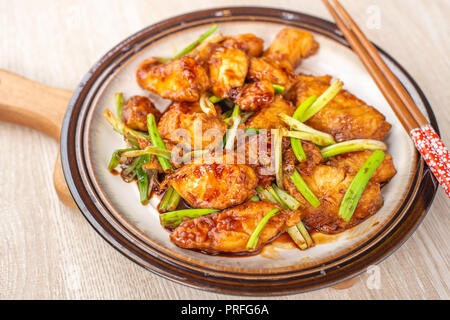 Deliziosa casa stufati dei tranci di pesce con scalogno in background in legno, Taiwan delicatezze, vista dall'alto, spazio di copia Foto Stock