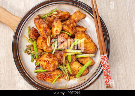 Deliziosa casa stufati dei tranci di pesce con scalogno in background in legno, Taiwan delicatezze, vista dall'alto, spazio di copia Foto Stock