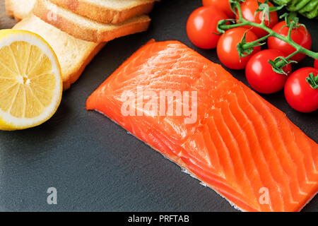 Materie filetto di salmone con verdure su ardesia Foto Stock