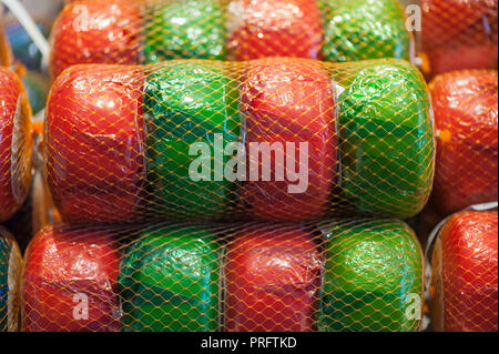 Al netto di verde e rosso e ruote di formaggio Gouda in un mercato in Paesi Bassi Foto Stock