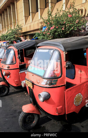 I risciò auto Bajaj aspettano i passeggeri fuori dalla stazione ferroviaria di Gondangdia a Giacarta, Indonesia Foto Stock