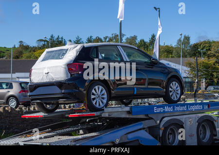 Nuovo di zecca Volkswagen auto viene consegnato a una concessionaria su un trasportatore di auto Foto Stock