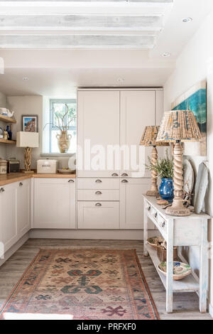 Coppia di lampade scolpito sulla console in bianco cucina attrezzata di Devon cottage Foto Stock