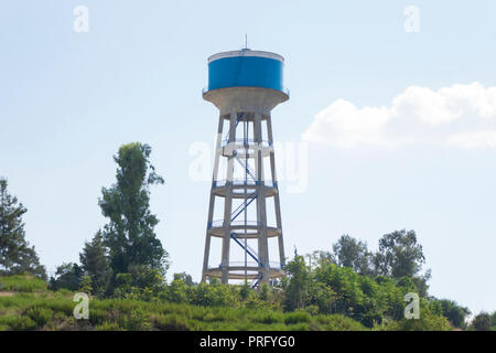 Water Tower dipinto di blu sotto il cielo blu Foto Stock