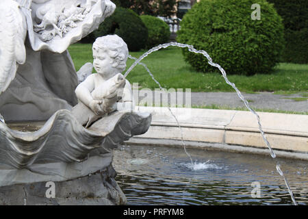 Bambino tenendo un pesce nelle sue mani ha voluto in pietra bianca sulla vecchia fontana in Maria Teresa piazza della città vecchia di Vienna, Austria, Europa Centrale Foto Stock