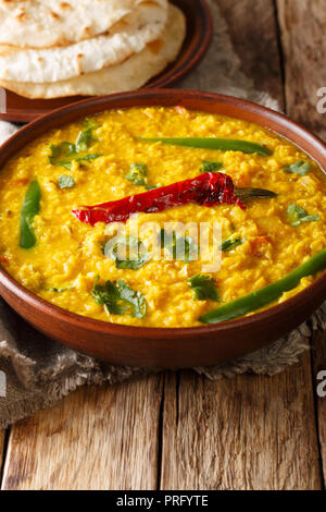 Dal Tadka giallo indiano di lenticchie zuppa di pane piatto su un sfondo di legno di close-up. In verticale Foto Stock