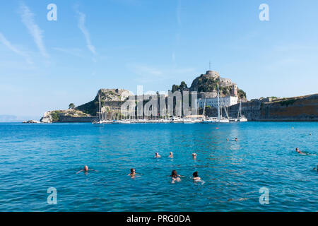 Persone nuotare nel mare vicino alla vecchia fortezza veneziana in Corfù Corfù, Grecia Foto Stock