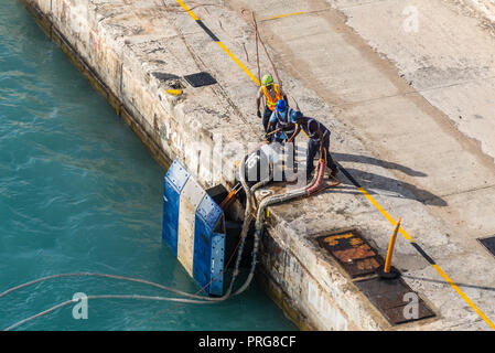 Bridgetown, Barbados - Dicembre 18, 2016: i lavoratori portuali sulla cima di ormeggio di una nave in porto di Porto di Bridgetown, Barbados isola dei Caraibi. Foto Stock