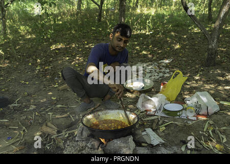 Velika Kladusa, in Bosnia ed Erzegovina. 23 Mar, 2018. Un rifugiato pakistano l uomo è visto la preparazione di cibo in un campo di rifugiati.Refugee Camp di Velika Kladusa, Bosnia sul confine croato. I rifugiati qui tentare di entrare in Europa attraverso la Croazia ed è noto come il gioco; dove si cammina per 2 o 3 settimane nel tentativo di raggiungere l'Italia dove essi si applicherà per il riconoscimento dello status di rifugiato. Credito: Enzo Tomasiello SOPA/images/ZUMA filo/Alamy Live News Foto Stock