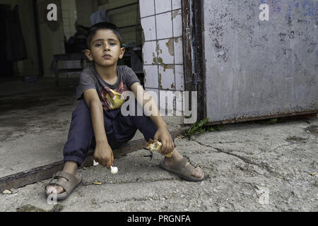 Velika Kladusa, in Bosnia ed Erzegovina. 23 Mar, 2018. Un ragazzo avendo visto situati holding qualcosa da mangiare al campo profughi.Refugee Camp di Velika Kladusa, Bosnia sul confine croato. I rifugiati qui tentare di entrare in Europa attraverso la Croazia ed è noto come il gioco; dove si cammina per 2 o 3 settimane nel tentativo di raggiungere l'Italia dove essi si applicherà per il riconoscimento dello status di rifugiato. Credito: Enzo Tomasiello SOPA/images/ZUMA filo/Alamy Live News Foto Stock