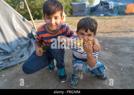 Velika Kladusa, in Bosnia ed Erzegovina. 23 Mar, 2018. Due ragazzi rifugiati sono visti mangiare il mais al campo profughi.Refugee Camp di Velika Kladusa, Bosnia sul confine croato. I rifugiati qui tentare di entrare in Europa attraverso la Croazia ed è noto come il gioco; dove si cammina per 2 o 3 settimane nel tentativo di raggiungere l'Italia dove essi si applicherà per il riconoscimento dello status di rifugiato. Credito: Enzo Tomasiello SOPA/images/ZUMA filo/Alamy Live News Foto Stock