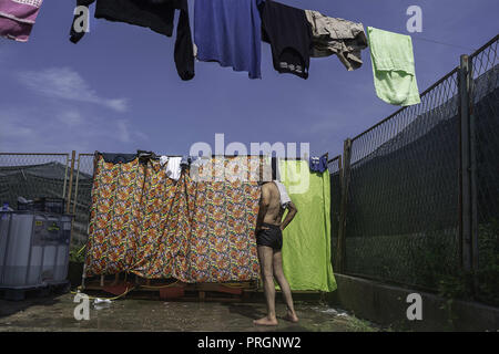 Velika Kladusa, in Bosnia ed Erzegovina. 23 Mar, 2018. Refugee l uomo è visto in piedi in attesa di doccia Refugee Camp.Refugee Camp di Velika Kladusa, Bosnia sul confine croato. I rifugiati qui tentare di entrare in Europa attraverso la Croazia ed è noto come il gioco; dove si cammina per 2 o 3 settimane nel tentativo di raggiungere l'Italia dove essi si applicherà per il riconoscimento dello status di rifugiato. Credito: Enzo Tomasiello SOPA/images/ZUMA filo/Alamy Live News Foto Stock