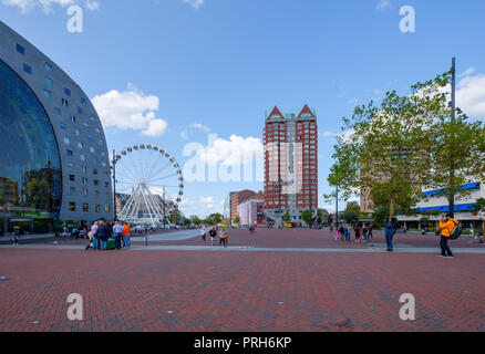 Grande piazza con gruppi di persone di fronte al famoso mercato hall di Rotterdam, Paesi Bassi. Accanto alla costruzione di una ruota panoramica Ferris. Foto Stock