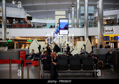 Inghilterra Heathrow Airport Terminal due passeggeri in attesa nella sala partenze Foto Stock