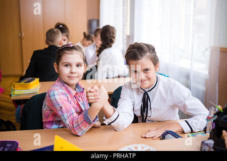 L'Ucraina. Kiev. Il 5 maggio 2018. Scuola Junior, college. Coppia due bambini di nazionalità caucasica, gli alunni di scuola, sit desk classe scuola camera. Sulla tabella libri Foto Stock