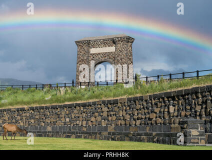 Rainbow oltre il Roosevelt arco all'entrata nord del Parco Nazionale di Yellowstone. Foto Stock