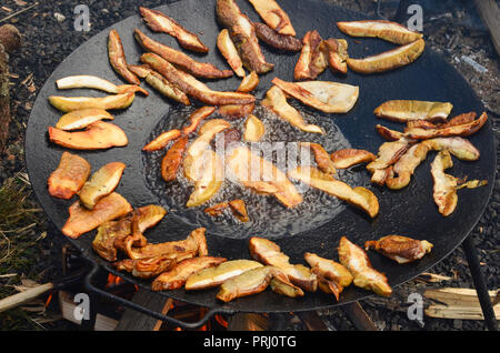 Preparazione del cibo all'aperto, tostatore pieno di funghi porcini funghi fritti in olio profondo pronto per essere servito Foto Stock