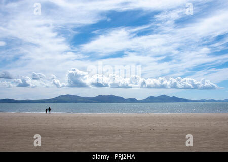 Guardando attraverso il Menai Straits dalla spiaggia di Baia di Llanddwyn verso Snowdonia Foto Stock