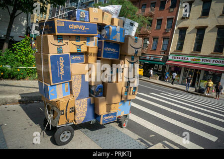 Un deliveryman da Lasership con il suo carrello carico di acquisti da personaggi del calibro di Walmart e fragrante, Amazon, e altri trudges attraverso il quartiere di Chelsea di New York sul suo nominato tornate, Mercoledì, 19 settembre 2018 . (Â©Â Richard B. Levine) Foto Stock