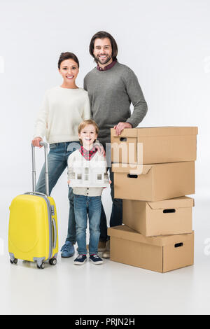 Ragazzo di cartone di contenimento casa pronta a muoversi con la sua famiglia nella nuova casa isolata su bianco Foto Stock