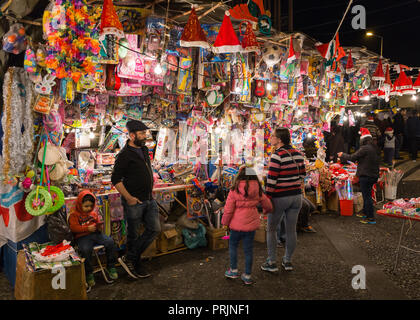 FUNCHAL, Portogallo - 7 dicembre 2016: famiglia in cerca di un negozio all'aperto per scegliere un giocattolo per natale nella città di Funchal, Madeira, Portogallo. Foto Stock