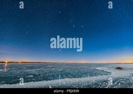 Orion e il cane Stelle (Procione e Sirius) con un incremento di oltre il lago ghiacciato MacGregor nel sud Alberta, il 2 febbraio 2017, su una chiara notte di luna, wit Foto Stock