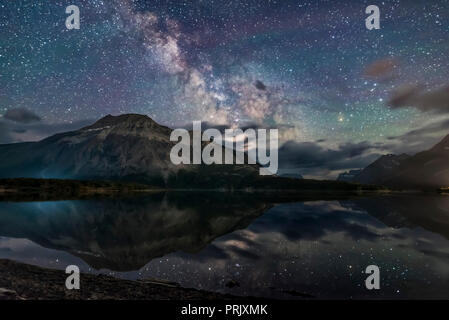 La Via Lattea si riflette nel insolitamente calme acque del Medio lago di Waterton da Driftwood Beach, nel Parco Nazionale dei laghi di Waterton, Alberta, Canada. T Foto Stock