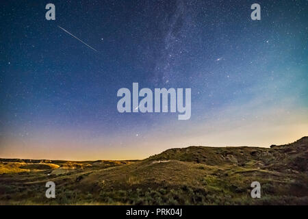 Due luminose Perseid meteore (le due migliori da 3 ore di riprese) oltre il paesaggio al chiaro di luna del Parco Provinciale dei Dinosauri, Alberta, su agosto 12/13, 2 Foto Stock