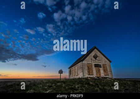 Il 1910 Liberty Schoolhouse, un classico pioneer one-room scuola, sull'Alberta prairie sotto le stelle nel crepuscolo di una notte di primavera. Moonlight f Foto Stock