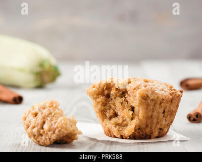 Vista ravvicinata di muffin con zucchine, carote, mela e cannella in polvere di legno grigio Sfondo. Verdure dolci muffin fatti in casa. Bambino-friendly ricetta idea. Copia dello spazio. DOF poco profondo Foto Stock