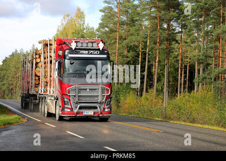 Salo, Finlandia. 28 settembre 2018: Rosso Volvo FH16 750 carrello registrazione di R.M. Trasporto Enberg Ab cale un registro di pino di carico su strada fiancheggiata da pini. Foto Stock