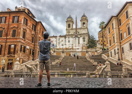 Un turista è scattare una foto della Scalinata di piazza di Spagna e la scalinata di Trinità dei Monti chiesa sulla piazza di Spagna Foto Stock