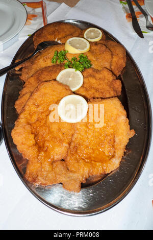 Wiener Schnitzel vom Kalb mit Zitronen Scheiben auf einer Platte Foto Stock